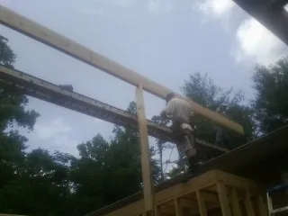 Carpenter setting a ridge beam over a new addition frame — Ice Dam Removal by Roofing Brothers in New Braintree