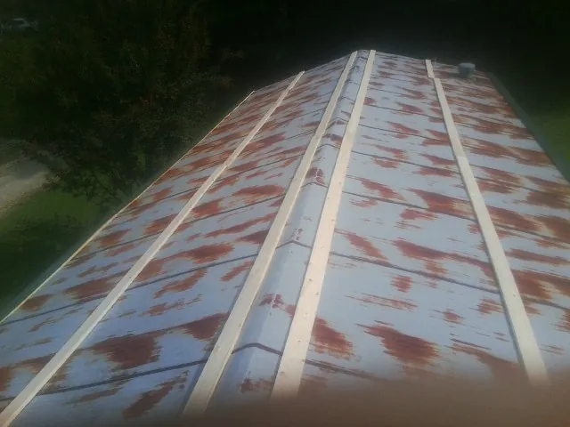 Rusted metal roof panels with new wood purlins before replacement — Storm Damage Roof Repair in New Braintree by Roofing Brothers