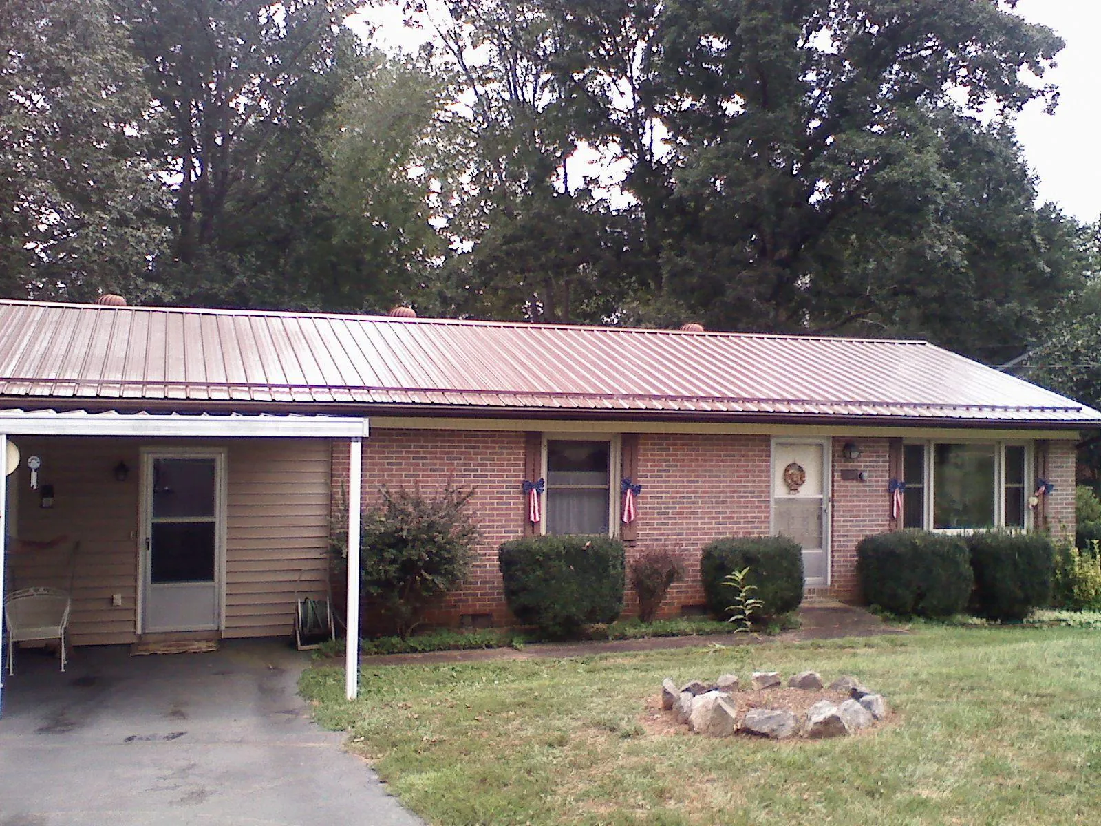 Bronze metal roof and carport on a brick ranch home — Roof Repair work by our crew in New Braintree